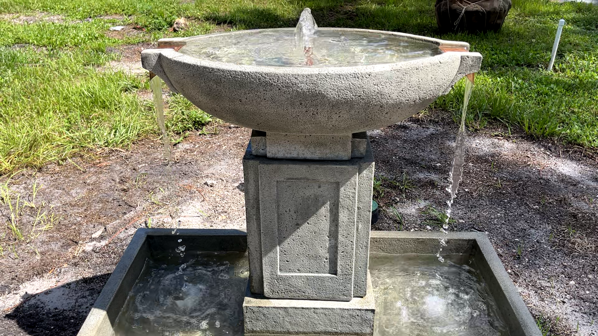 Front view of the Austin Fountain with a bubbling water feature flowing from four copper spillways into the lower basin