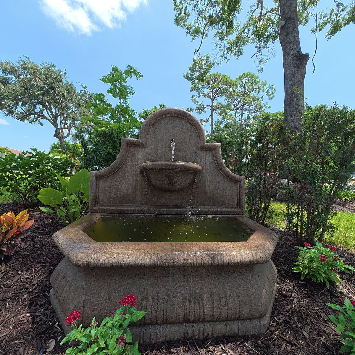 Andalusia Fountain with architectural back panel, upper bowl, and flowing water in a garden setting