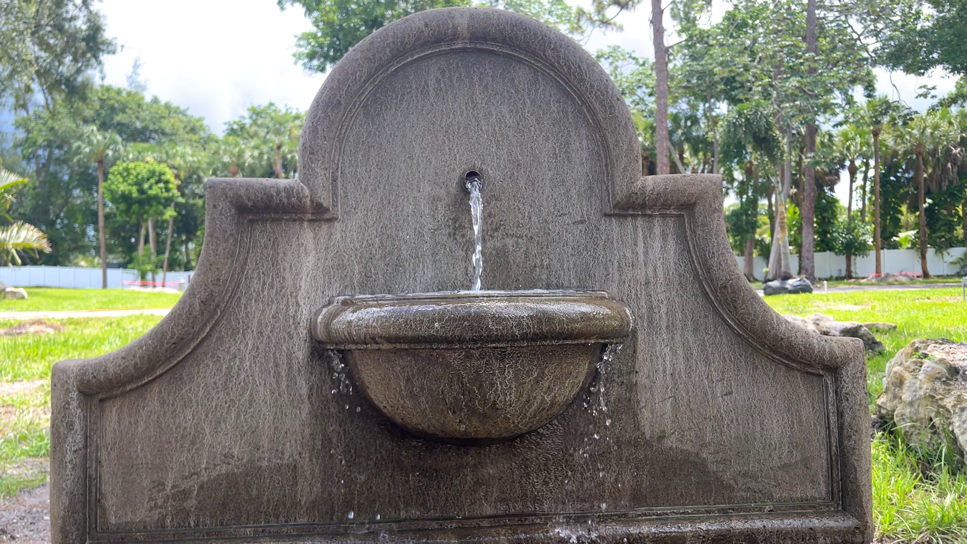 Front view of the Andalusia Fountain showcasing the elegant cast stone wall fountain with flowing water and rounded basin