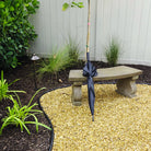 Arles cast stone garden bench beside ornamental grasses and a gravel garden path
