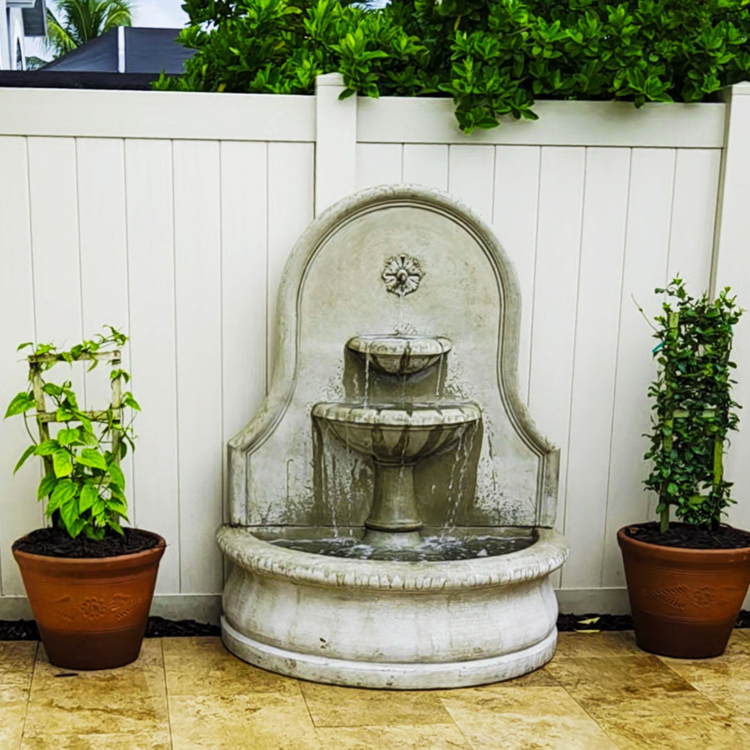 Front view of the Estancia Fountain with water flowing through two tiered bowls into the large basin