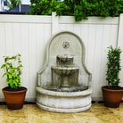 Front view of the Estancia Fountain with water flowing through two tiered bowls into the large basin