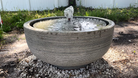 Angled front view of the Girona Fountain highlighting the modern textured cast stone bowl and bubbling water