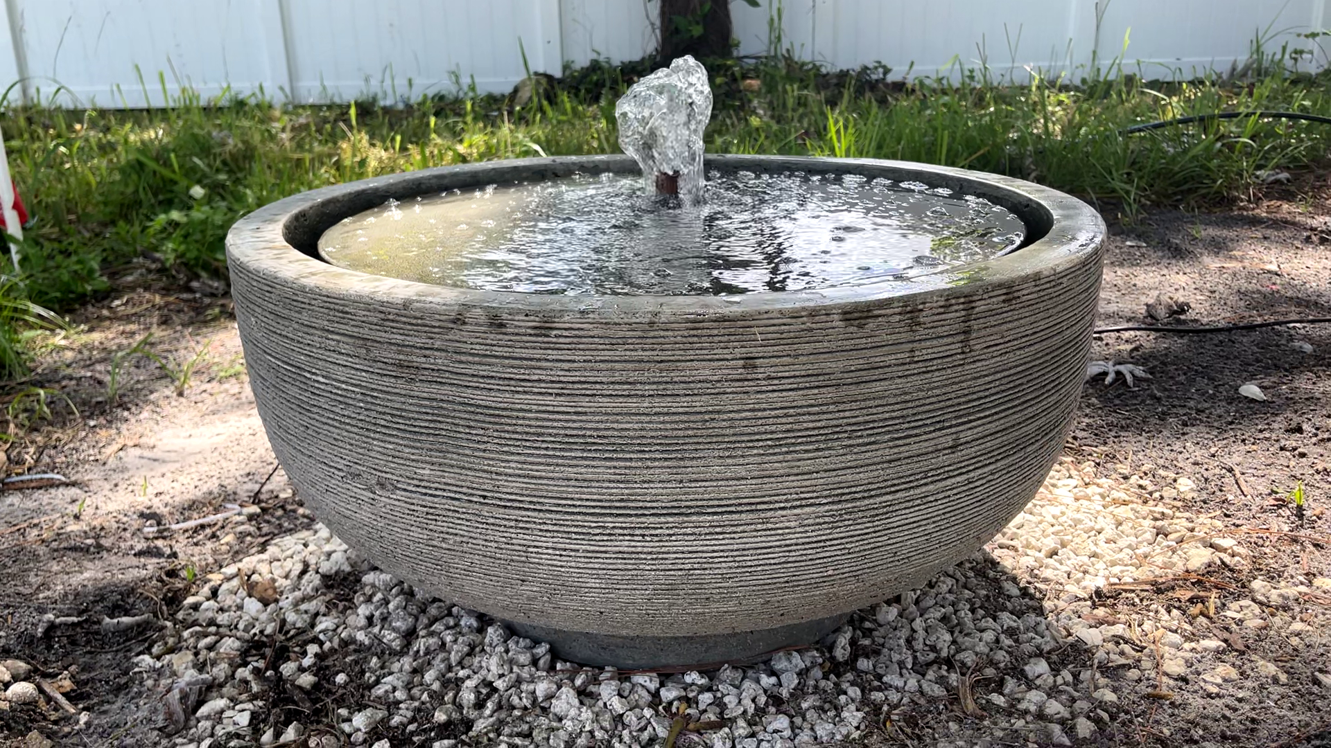 Angled front view of the Girona Fountain highlighting the modern textured cast stone bowl and bubbling water