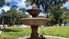 Wiltshire Fountain with two cascading tiers and an ornamental finial in a landscaped outdoor setting