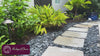 Rumba Fountain in Riviera Blue with bubbling water installed in a tropical residential landscape